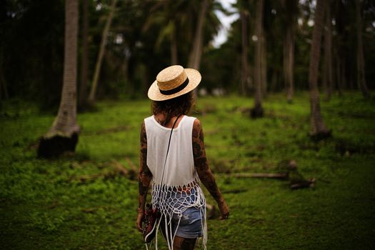 Girl with tattoos in tropical garden