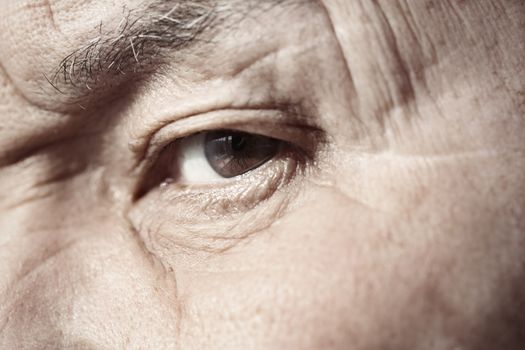 Close-up view on the eye of elderly human