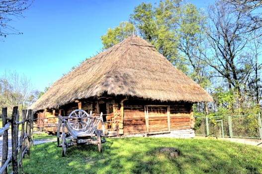 wooden log house prosperous peasant, the cart stands in the yard
