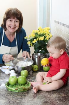 Grandmother and baby boy baking in the kitchen