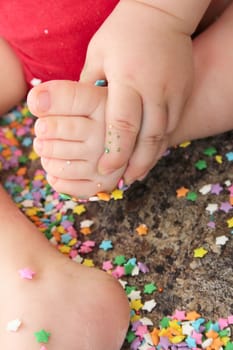 Baby sitting on the counter amongst sprinkles