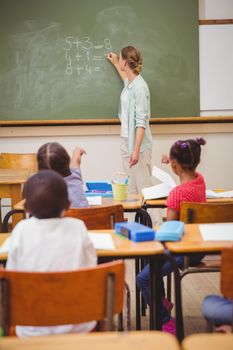 Teacher writing mathematics on board at the elementary school