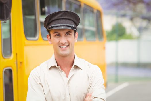 Smiling bus driver looking at camera outside the elementary school