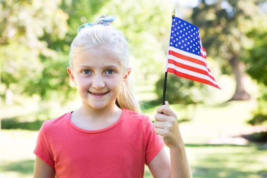 Little girl waving american flag on a sunny day