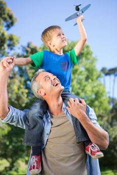 Father and son having fun in the park on a sunny day