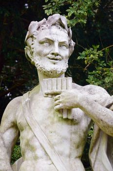 Stone statue of pan with pipes