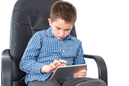 Close up Serious Male Kid Sitting on an Office Chair, Busy with his Tablet Computer, Isolated on White Background.