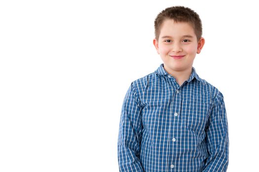 Portrait of a Cute 10 Year Old Boy with a Mischievous Sweet Smile, Standing Against White Background with Copy Space.