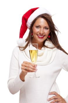 Playful woman wearing a festive red Santa hat and holding a flute of champagne celebrating Christmas blowing a kiss across the palm of her hand with a mischievous smile, on white