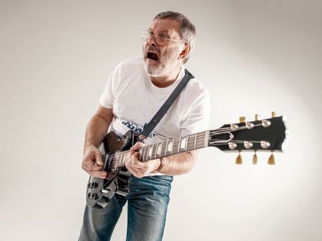 Portrait of a guitar player exciting music on gray background