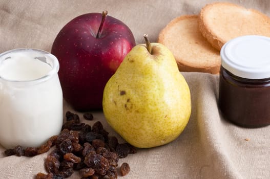 breakfast served with yogurt, apple and pear on a towel