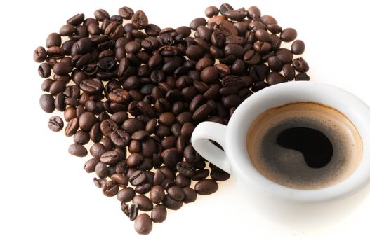 Heart shape made from coffee beans and cup of coffee