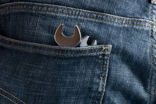 Working tools in the back pocket of old used jeans.