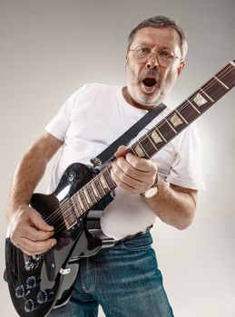 Portrait of a guitar player exciting music on gray background