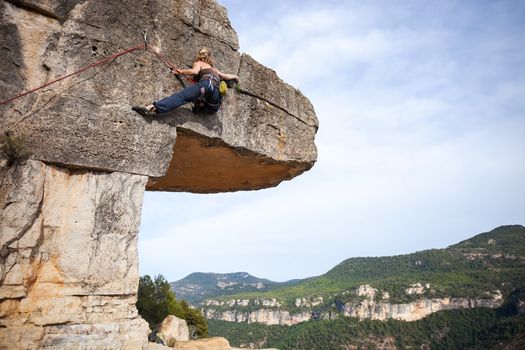 Woman climber on challenging route on cliff