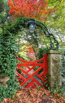 The little red gate at Bebeah Gardens in Autumn.  The parklands were originally built by Edward Cox in 1880.  Sprawling over many acres the garden includes various vistas of formal country garden. Mt Wilson