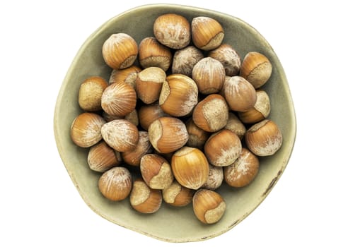 hazelnuts in a ceramic bowl isolated on white