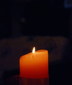photo of a red candle against dark background