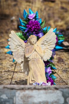 Outdoor grave marker with floral decoration and stone angel