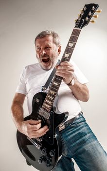 Portrait of a guitar player exciting music on gray background