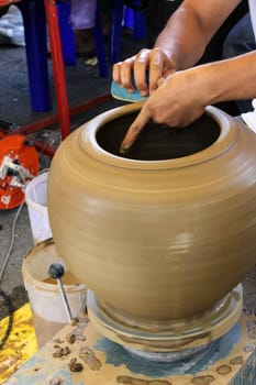 Hands of a potter making in clay on pottery wheel