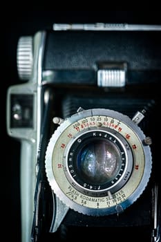 Old Kodak bellows camera isolated on black background