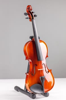 Violin front viewon a stand isolated on gray