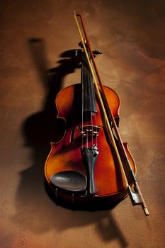 Vintage violin with shadow on old canvas background