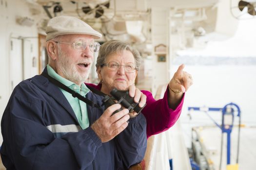 Happy Senior Couple Enjoying The View From Deck of a Luxury Passenger Cruise Ship.