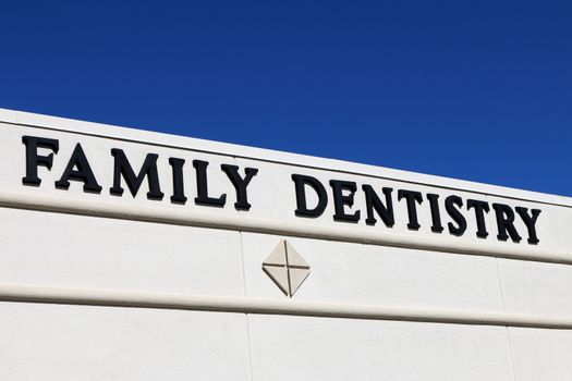"Family Dentistry" sign on the side of a building indicating the specialty practiced inside.