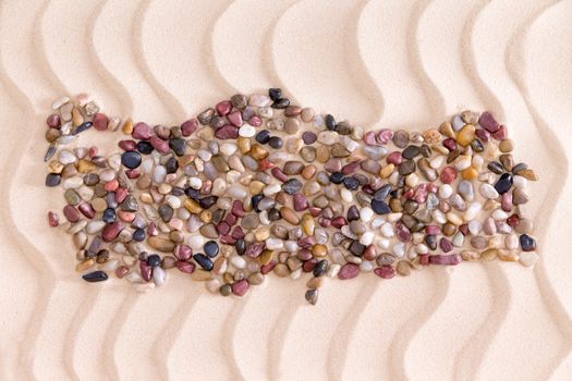 Travel concept with a creative Turkish map formed of colorful water worn agate and quartzite pebbles on decorative golden beach sand with a rippling wavy pattern