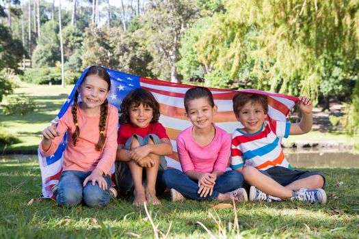Happy little friends with american flag on a sunny day