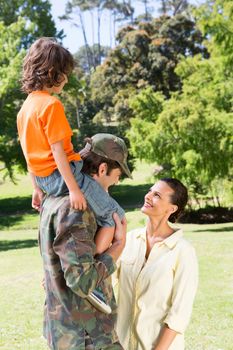 Happy soldier reunited with family on a sunny day