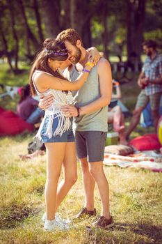 Hipster couple smiling and hugging at a music festival 