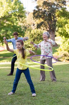 Extended family playing with hula hoops on a sunny day
