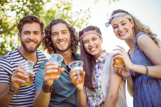 Hipster friends having a beer together on a summers day