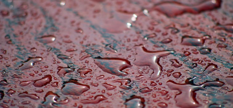 raindrops on a red table surface, photo of