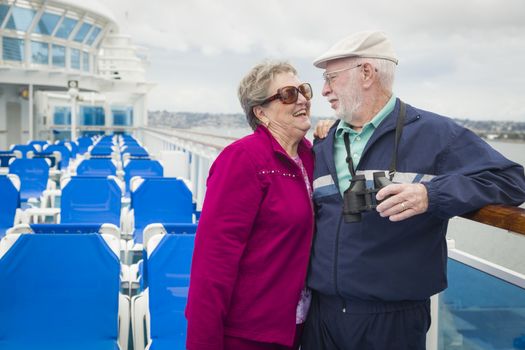 Happy Senior Couple Enjoying The View From Deck of a Luxury Passenger Cruise Ship.