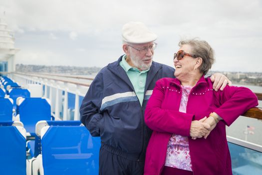 Happy Senior Couple Enjoying The View From Deck of a Luxury Passenger Cruise Ship.