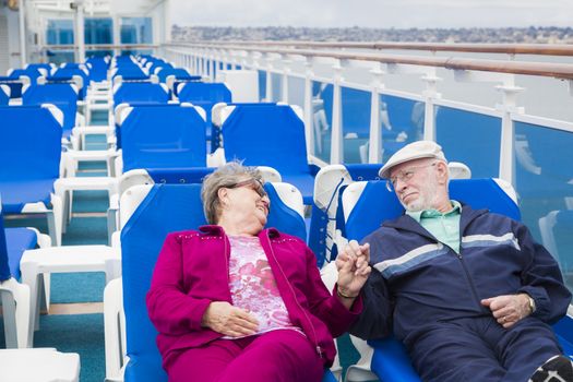 Happy Senior Couple Relaxing On The Deck of a Luxury Passenger Cruise Ship.