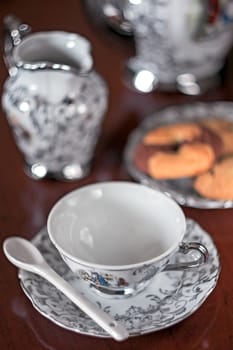 image depicting an elegant teacup decorated in the foreground