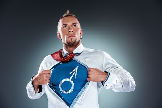 businessman acting like a super hero and tearing his shirt off on a gray background