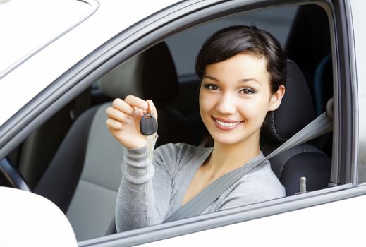 Pretty girl in a car showing the key