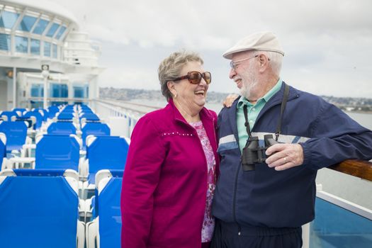 Happy Senior Couple Enjoying The View From Deck of a Luxury Passenger Cruise Ship.