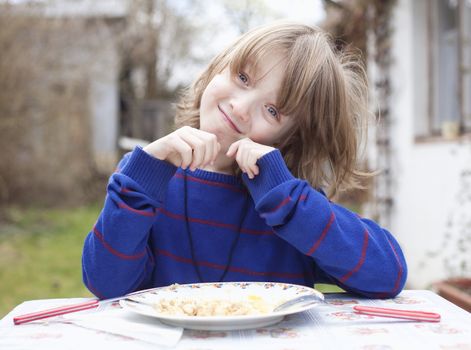 Boy with Blond Hair Eating Outdoors Smiling