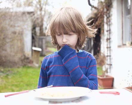 Boy with Blond Hair Looking at Food Thinking
