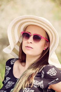 Cheerful fashionable woman in stylish hat, frock and sunglasses Happy brunette girl with long hair in warm spring day