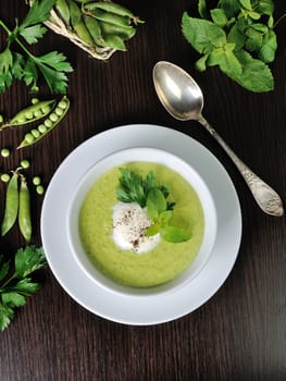 Portion cream soup with green peas with mint cream