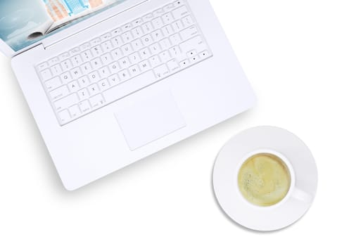White laptop and cup of coffee on plate on isolated white background, top view. Closed up