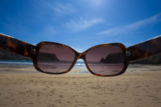 View through sunglasses on a sandy beach